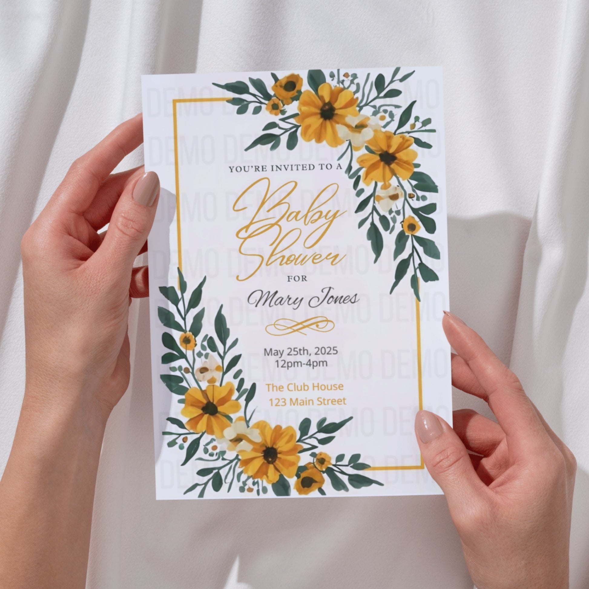 Baby shower invitation with yellow flowers held by hands against a white background