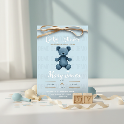 Baby shower invitation with a blue teddy bear on a light blue background, surrounded by decorative ribbons and blocks.